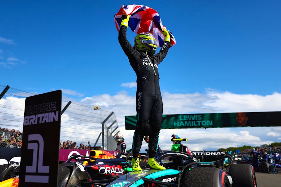 Sir Lewis Hamilton holds aloft the Union Jack flag after his sensational British Grand Prix victory.