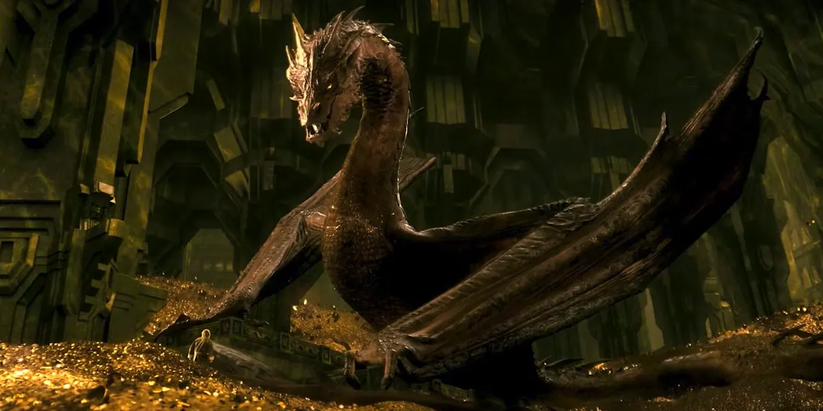 Smaug, a gigantic, mean-looking dragon, looms over a tiny hobbit in his lair