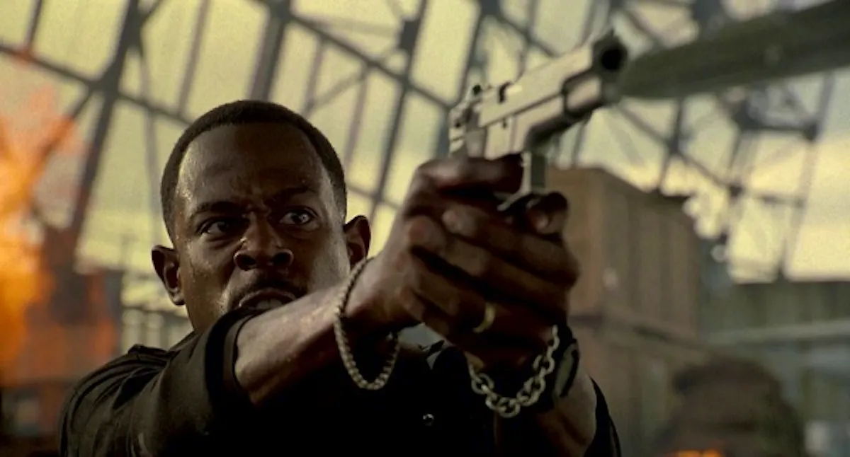  In an aircraft hangar, Marcus points a gun at an unseen bad guy.