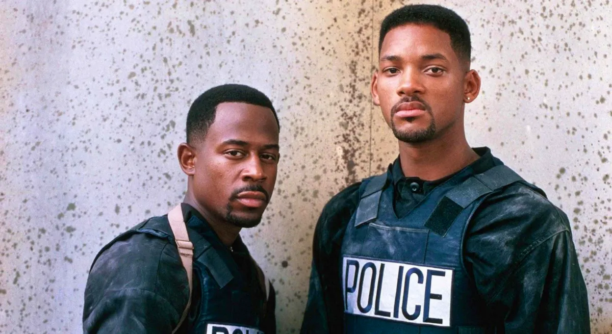 Mike (Will Smith) and Marcus (Martin Lawrence), wearing dirty riot gear, stare coolly at the camera.