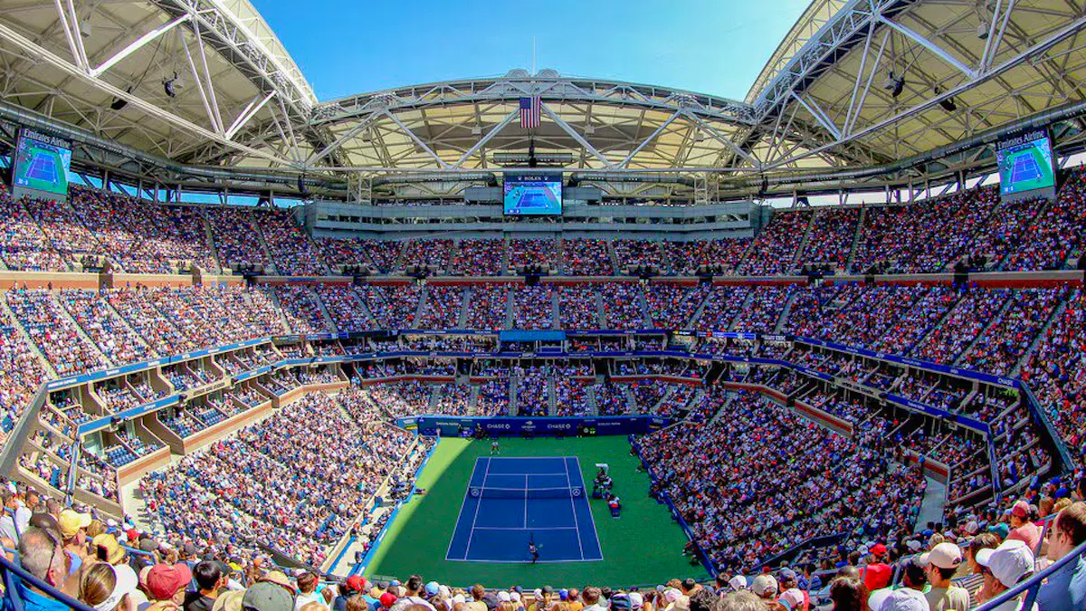 A packed Arthur Ashe Stadium watches on as players compete on court.