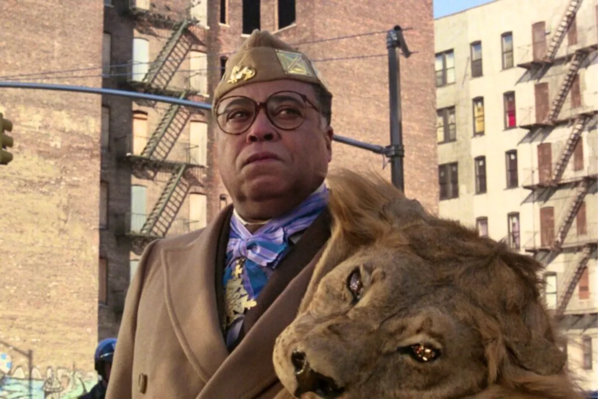 Jaffe, an African king dressed in a suit and lion skin, looks noble but suspcious while standing in a New York alley