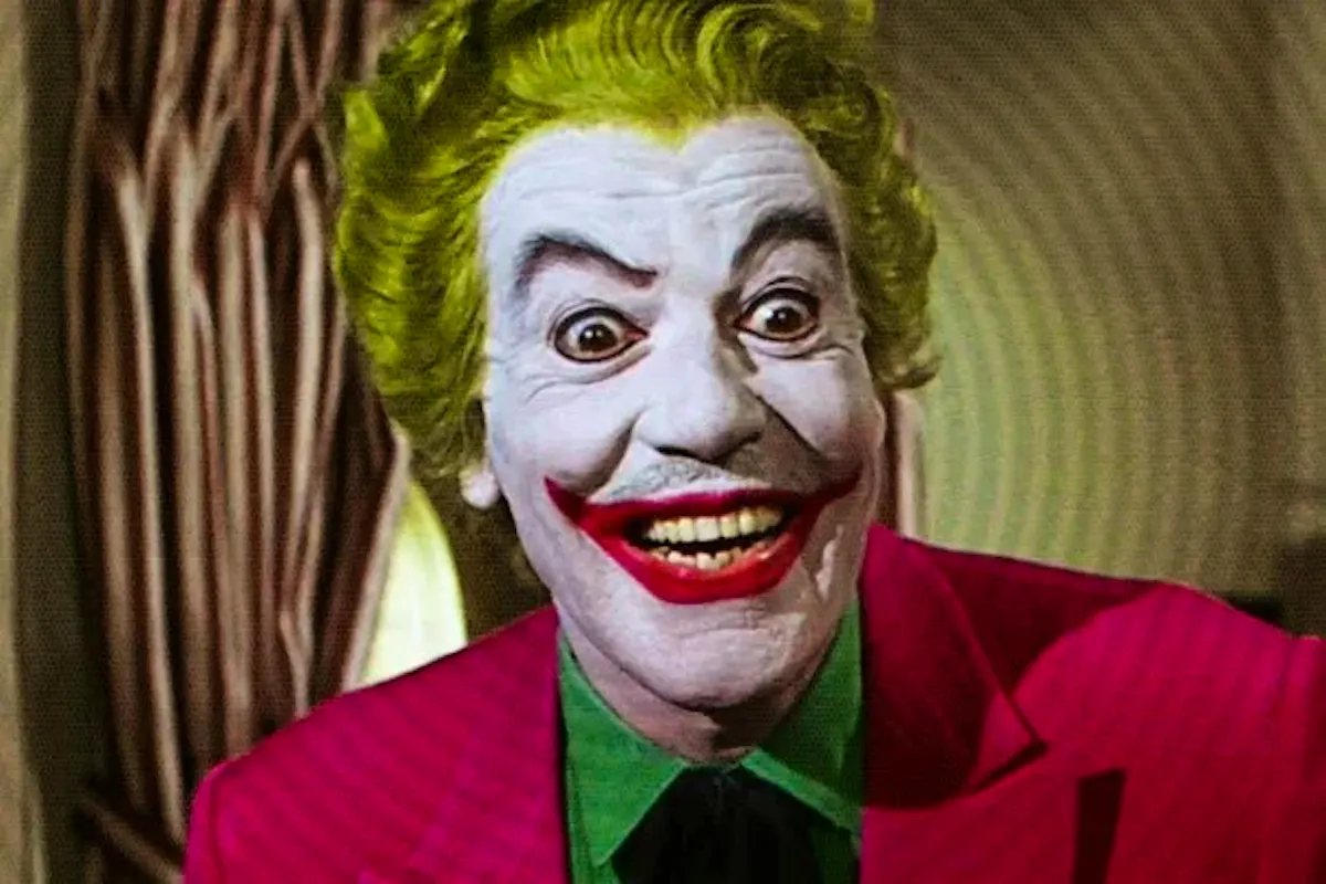 Cesar Romero, in Joker makeup, grinning maniacally