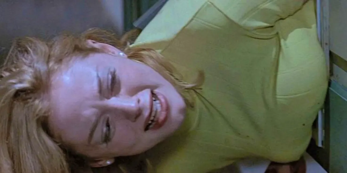 Tatum, played by Rose McGowan, stuck in the catflap in a garage door