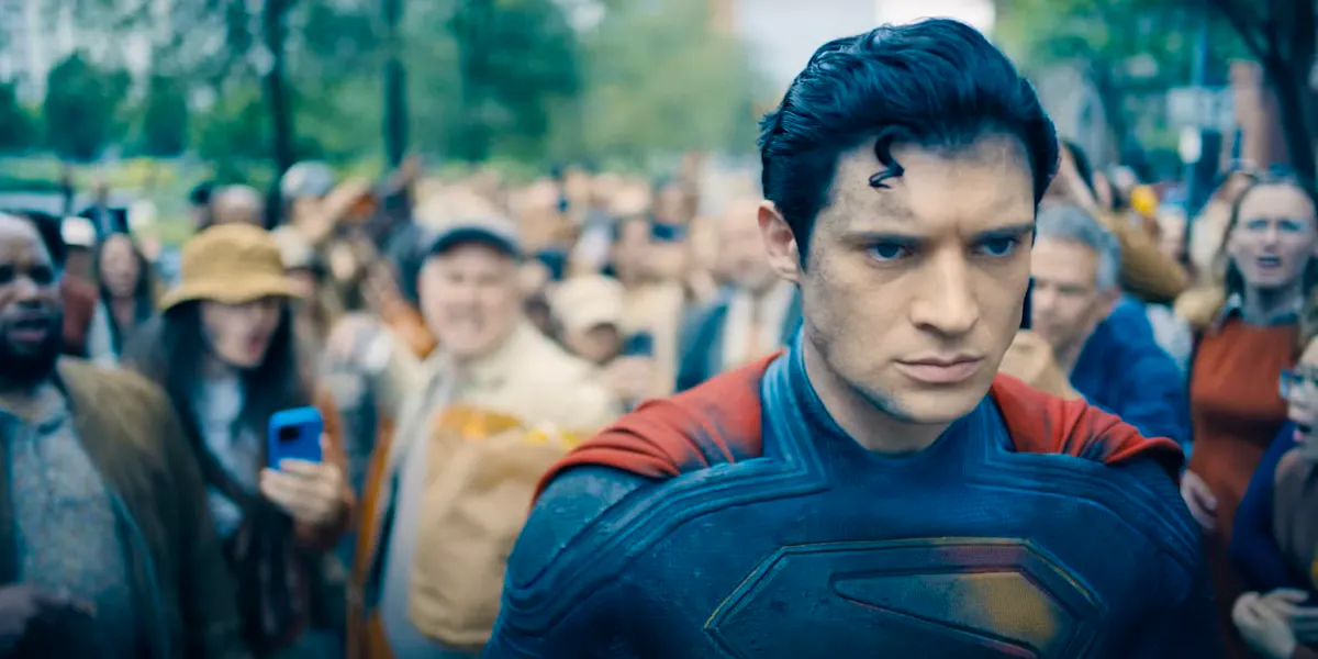 Superman, here played by David Corenswet, walks determinedly away from an angry crowd 