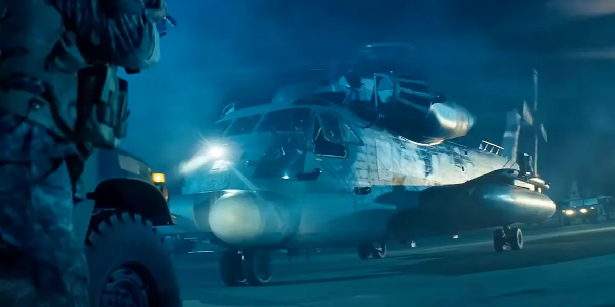A military helicopter sitting on a landing pad in the middle of a military base